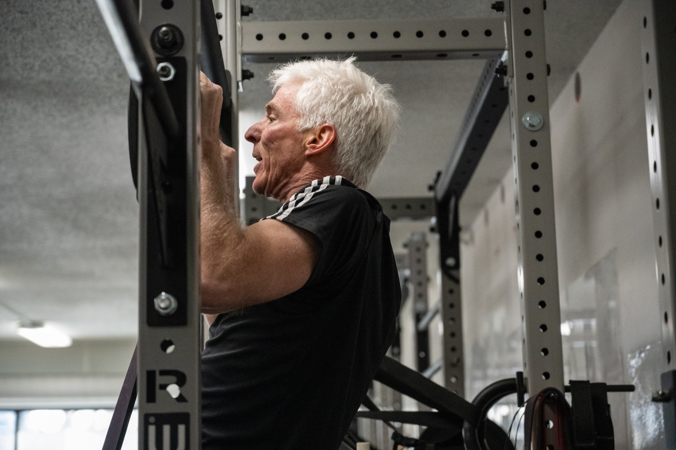 Athlete performing a pull up with help from a resistance band in Strength class at The Power House in Highland park